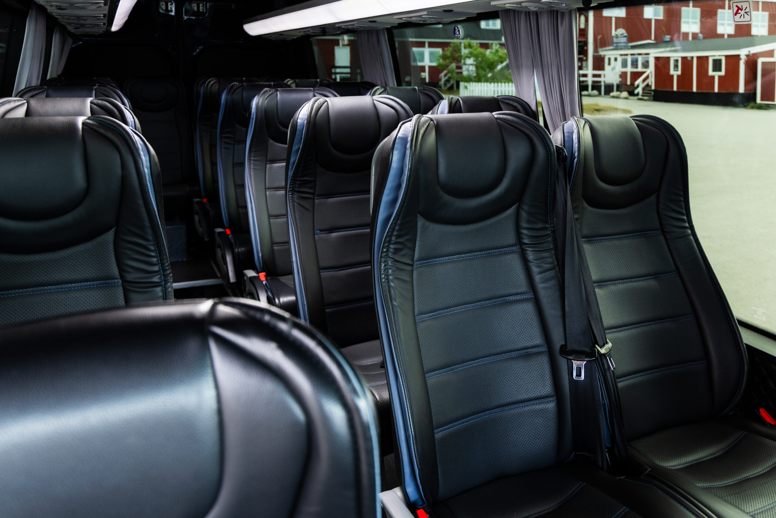 Empty bus interior with rows of black leather seats